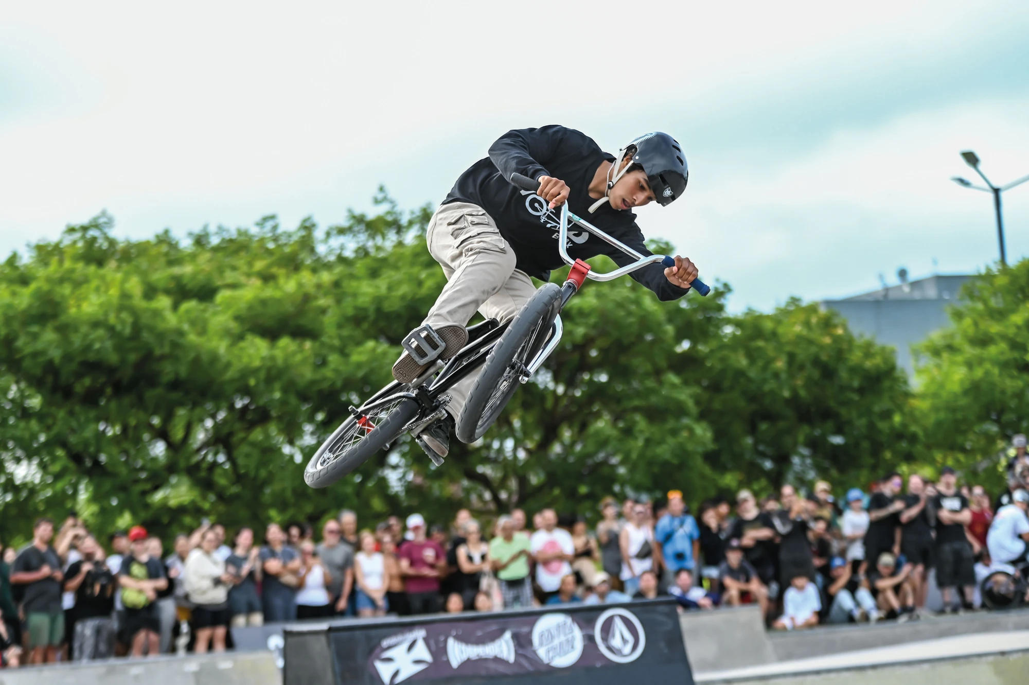 Una persona realiza un salto en BMX ante público y árboles. Fotografía de archivo difundida por GCBA.